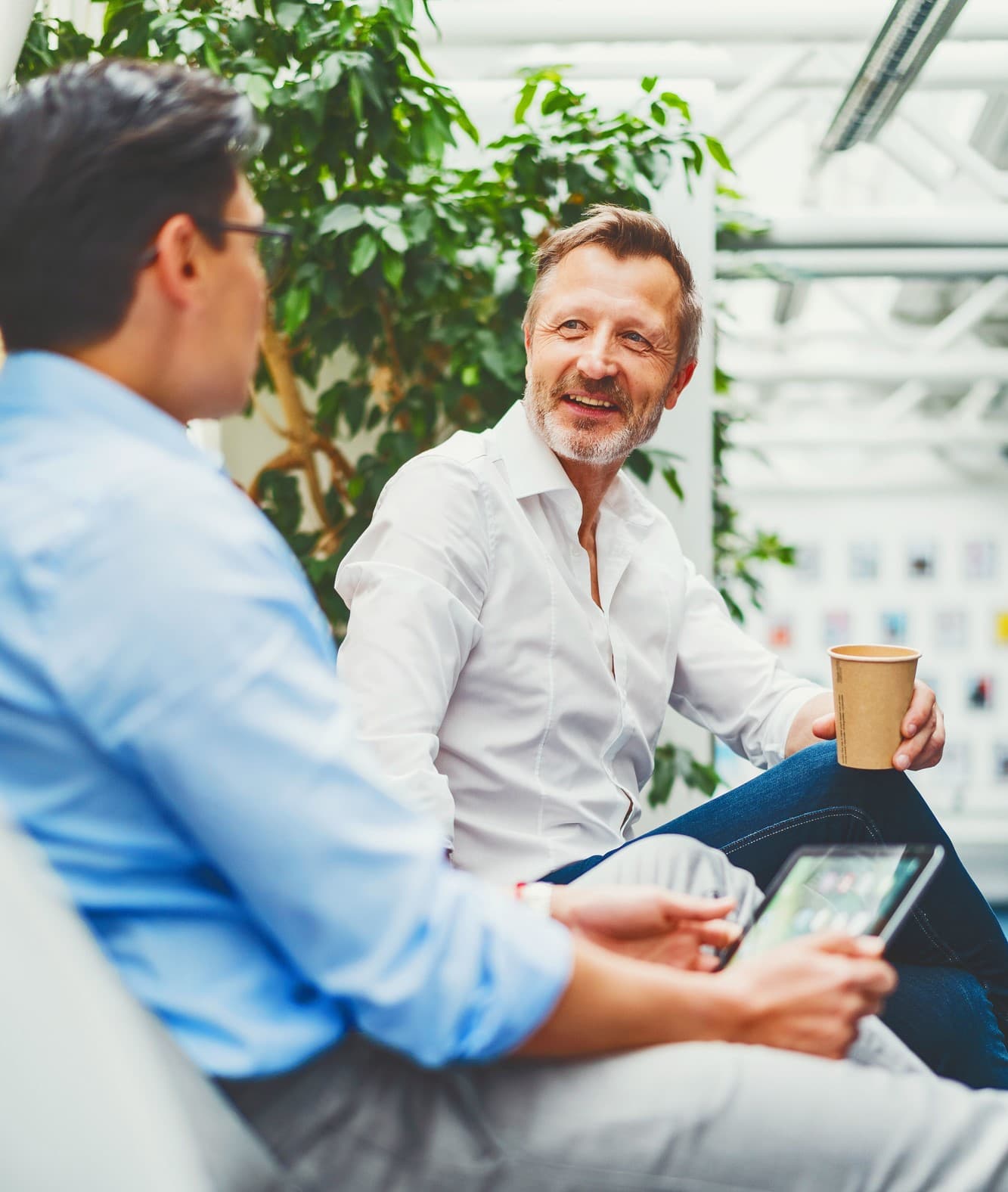 Geschäftsfreunde sitzen zusammen und trinken einen Kaffee B2B
