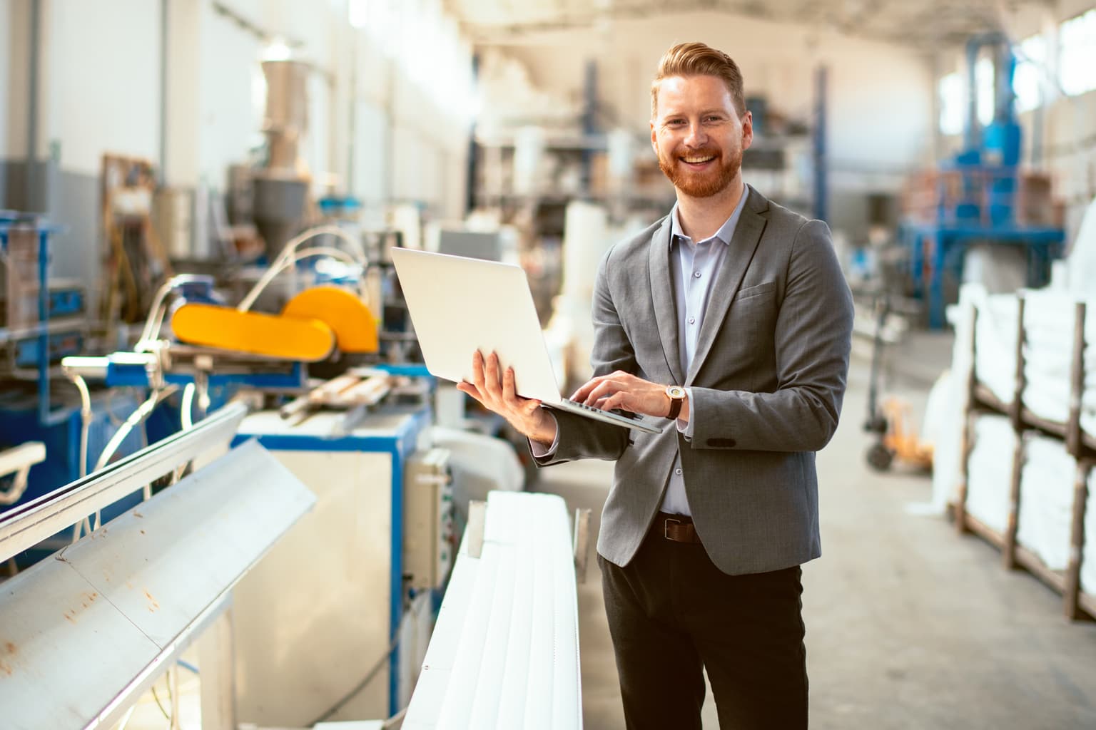Ein Mann steht in einer Lagerhalle und bedient sein