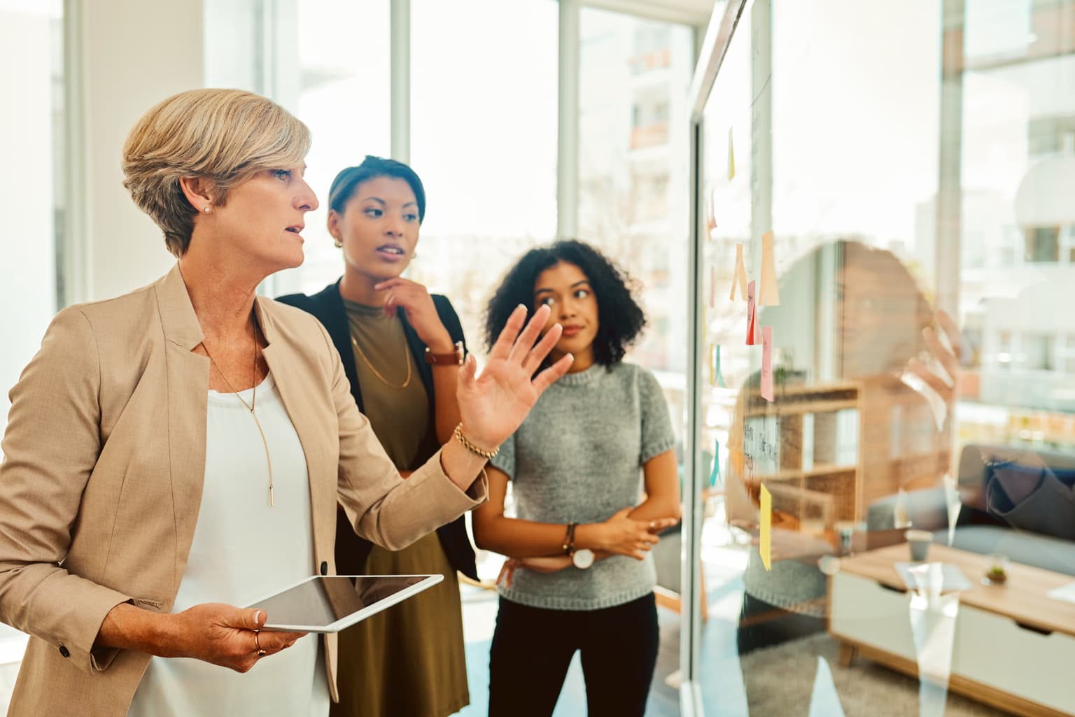 B2B Implementieren und integrieren, Frau bespricht mit Team die Notizzettel