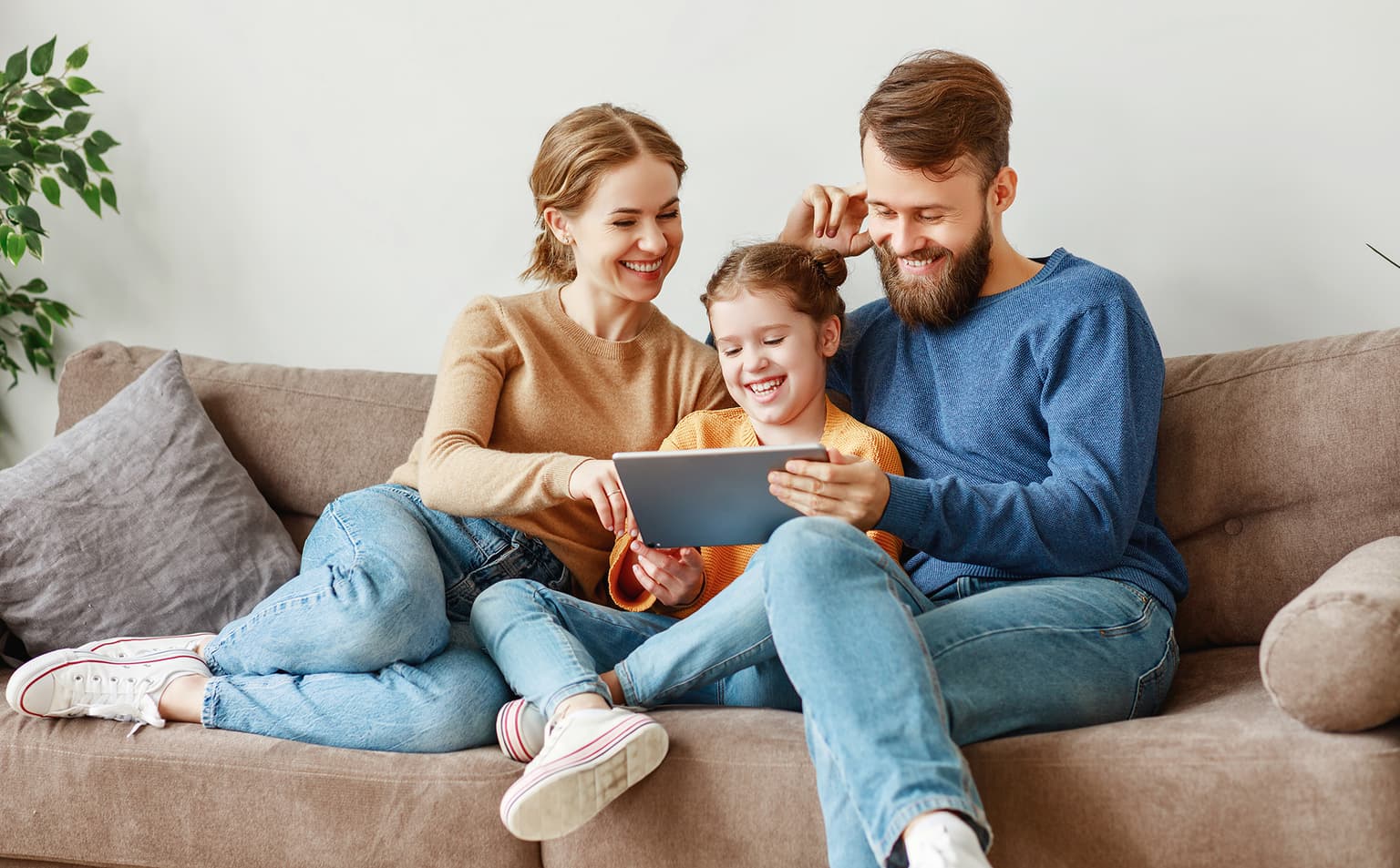 waipu.tv Für die ganz Familie, Familie sitzt auf der Couch und bedient ein Tablet