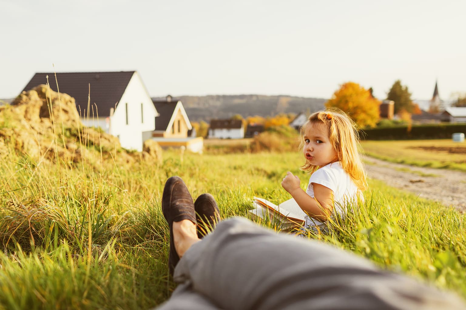 Deutsche Glasfaser Nachhaltigkeit Kind sitzt mit Elternteil im Feld i Grünen