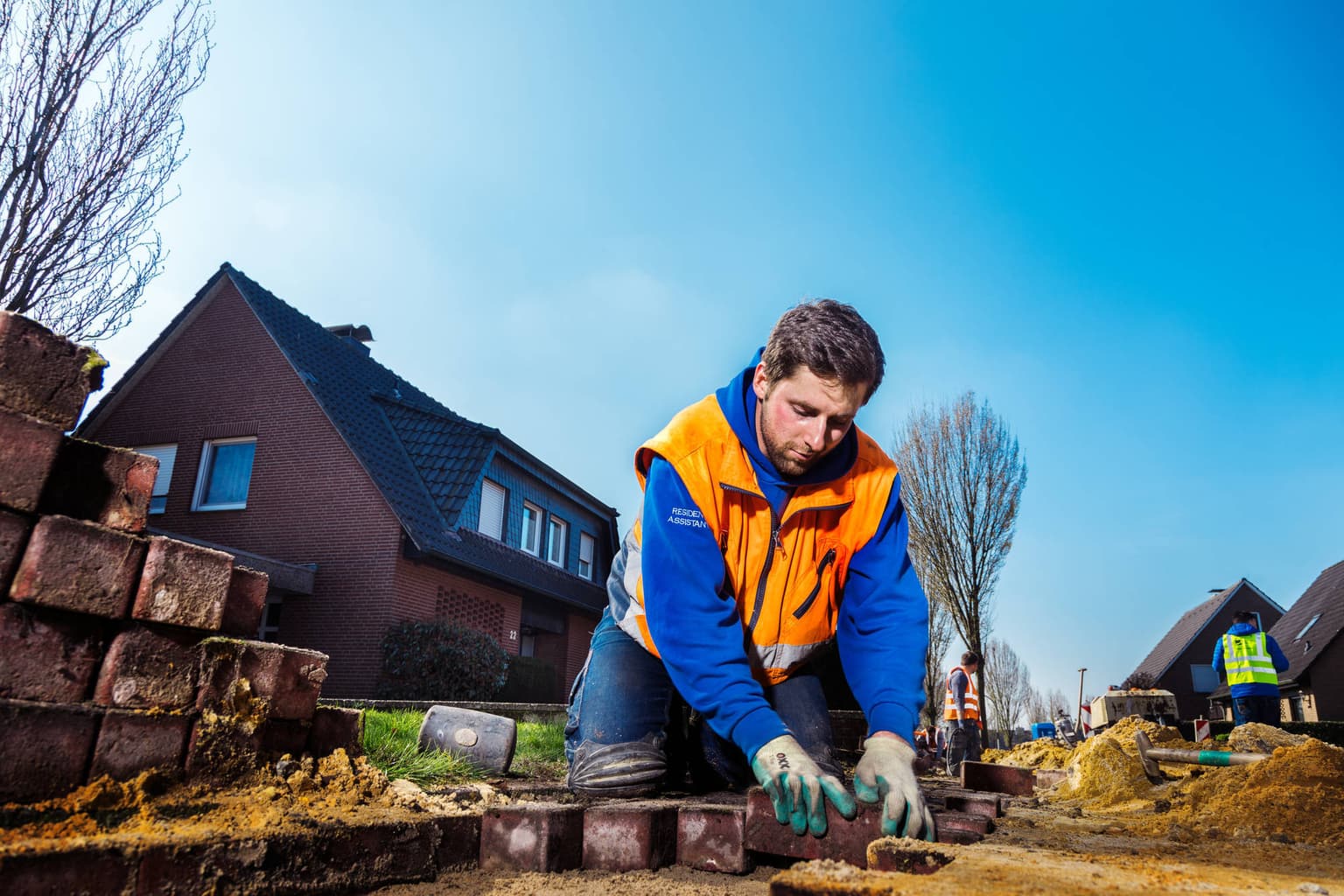 Bauprozess - Bauarbeiter verlegt Glasfaser verschließt die Straße