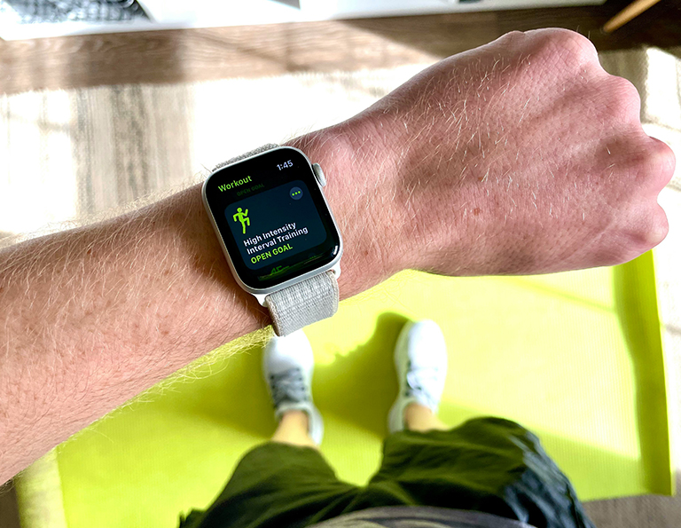 Ein Mann zeigt sein Handgelenk, an dem sich eine Smartwatch mit Fitness-Tracker befindet.